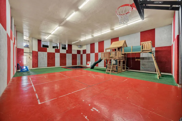 Indoor recreation space featuring a red-and-white checkered wall design and fluorescent ceiling lighting