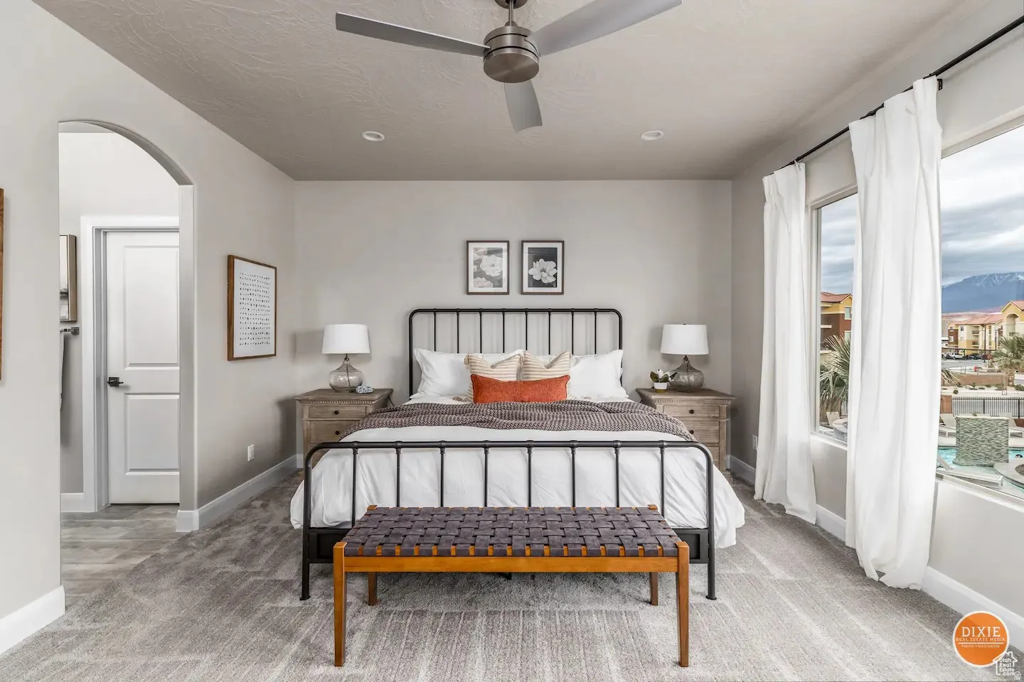 Spacious room featuring broad windows with mountain scenery, a ceiling fan, recessed lighting, an arched doorway, and patterned carpeting