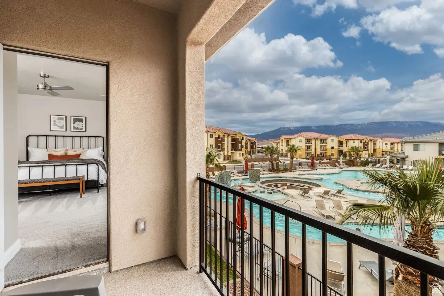 Private balcony featuring a black metal railing and stucco exterior