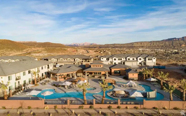Expansive pool area featuring a winding river, multiple lounge areas with umbrellas, and palm tree accents
