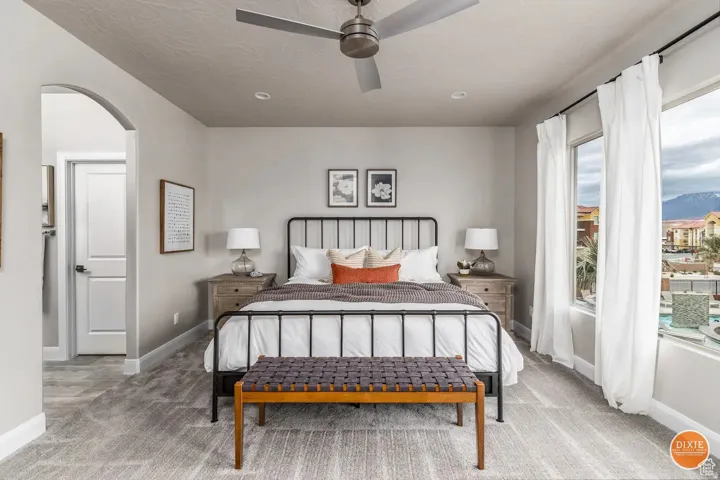 Spacious room featuring broad windows with mountain scenery, a ceiling fan, recessed lighting, an arched doorway, and patterned carpeting
