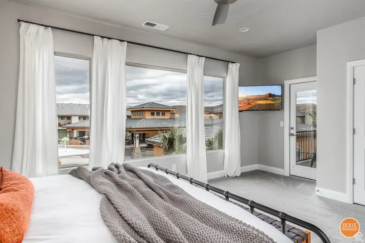 Bright interior room featuring a wall of four windows, a glass-panel exterior door, and a ceiling fan