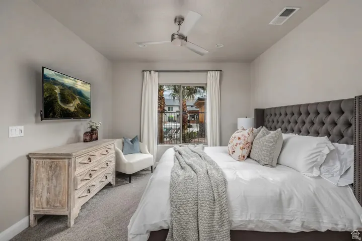 Carpeted room featuring a tufted upholstered headboard, recessed lighting, and a ceiling fan