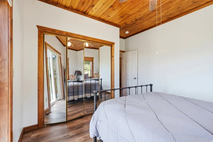 Room featuring a wood-finish ceiling, white walls, and wood-finish flooring