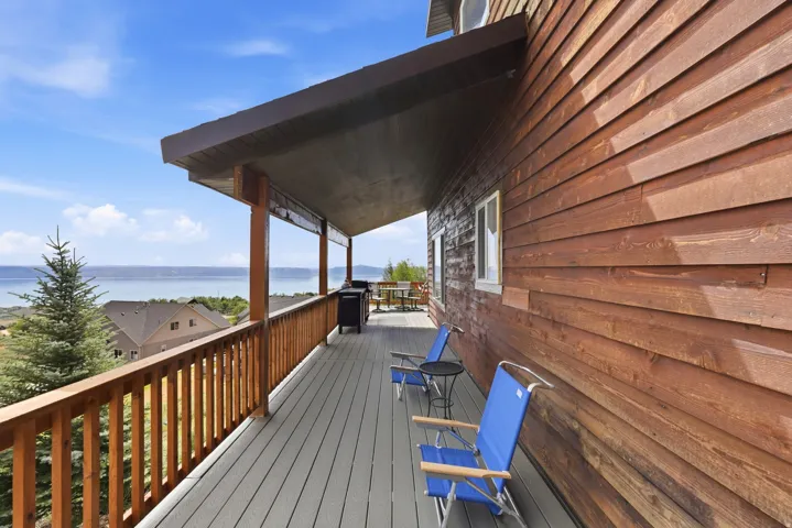 Expansive covered deck featuring composite decking and a wooden railing