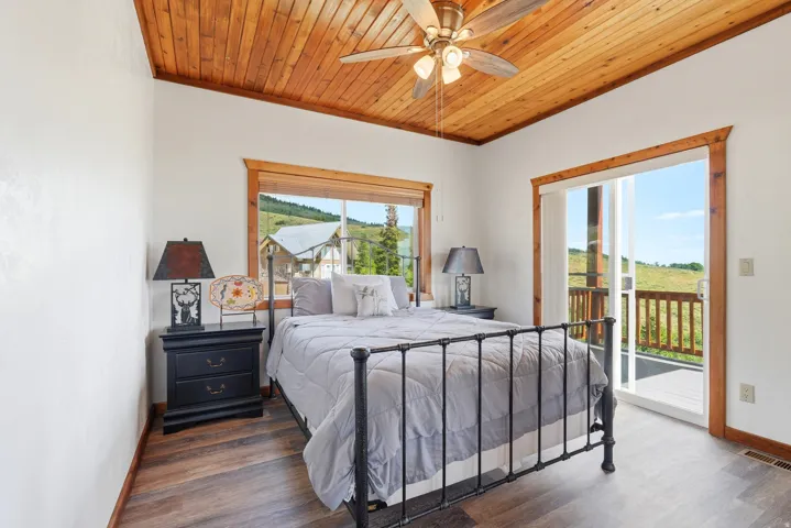 Wood-finish flooring with a wood plank ceiling and ceiling fan