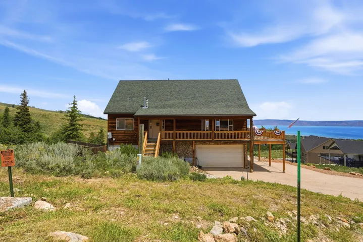 Wood-sided residence featuring a multi-level deck and an attached garage