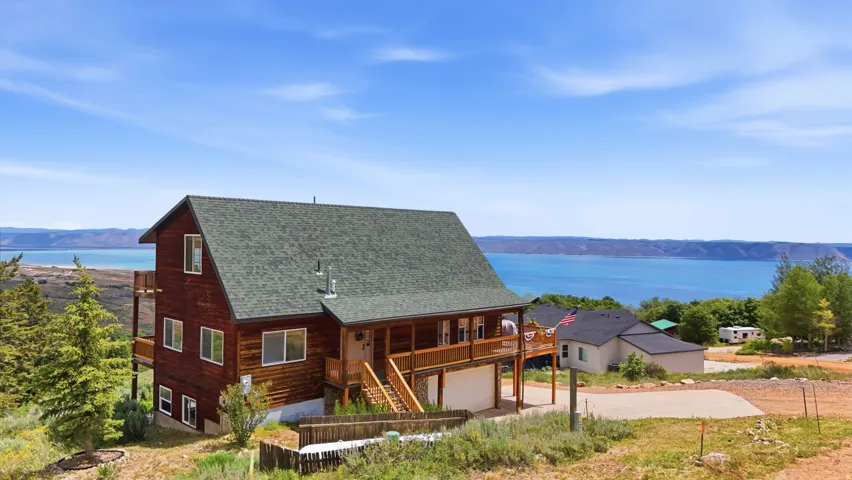 Multi-level residence featuring a dark wood-sided exterior, green shingle roof, and multiple balconies