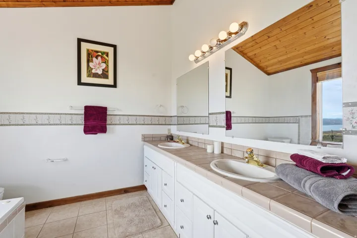 Bathroom featuring a dual vanity, tile flooring, and a wood-paneled ceiling