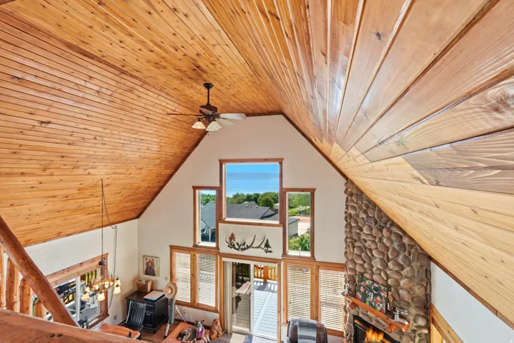 Vaulted wood-paneled ceiling with a central ceiling fan