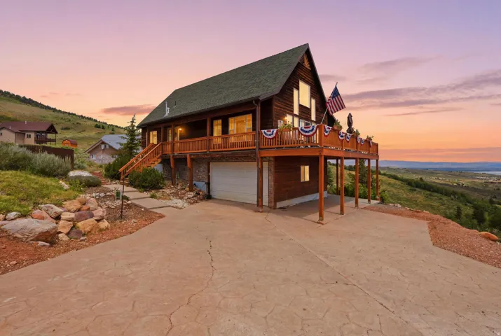 Two-story wood-sided residence featuring a gabled roof and an expansive upper-level deck