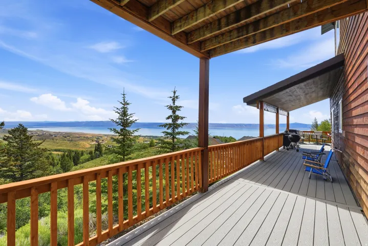Expansive outdoor deck featuring wood-look railing, composite decking, and a cedar shake exterior