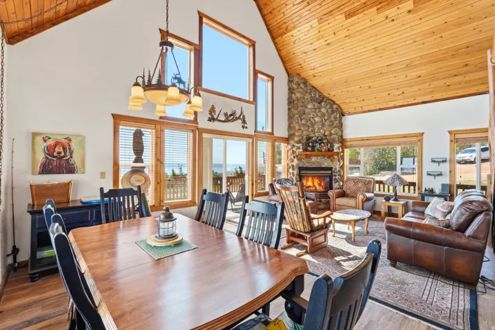 Vaulted wood-paneled ceilings over an open-concept living area with a stone fireplace