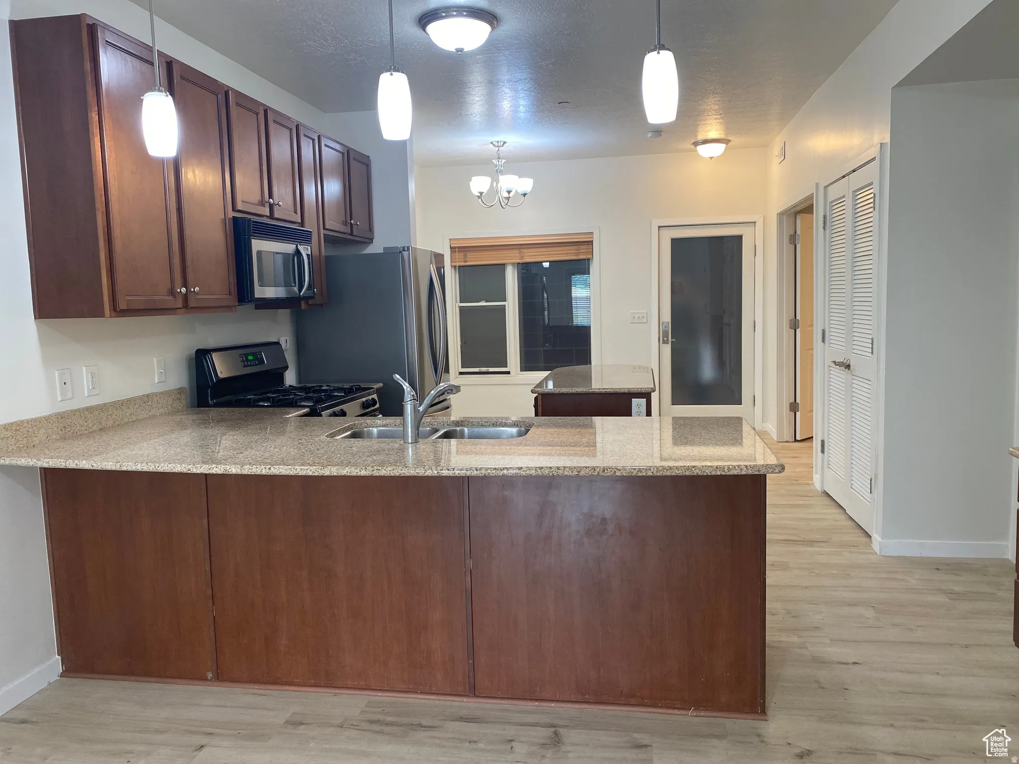 Kitchen featuring wood cabinetry, stainless steel appliances, and stone countertops
