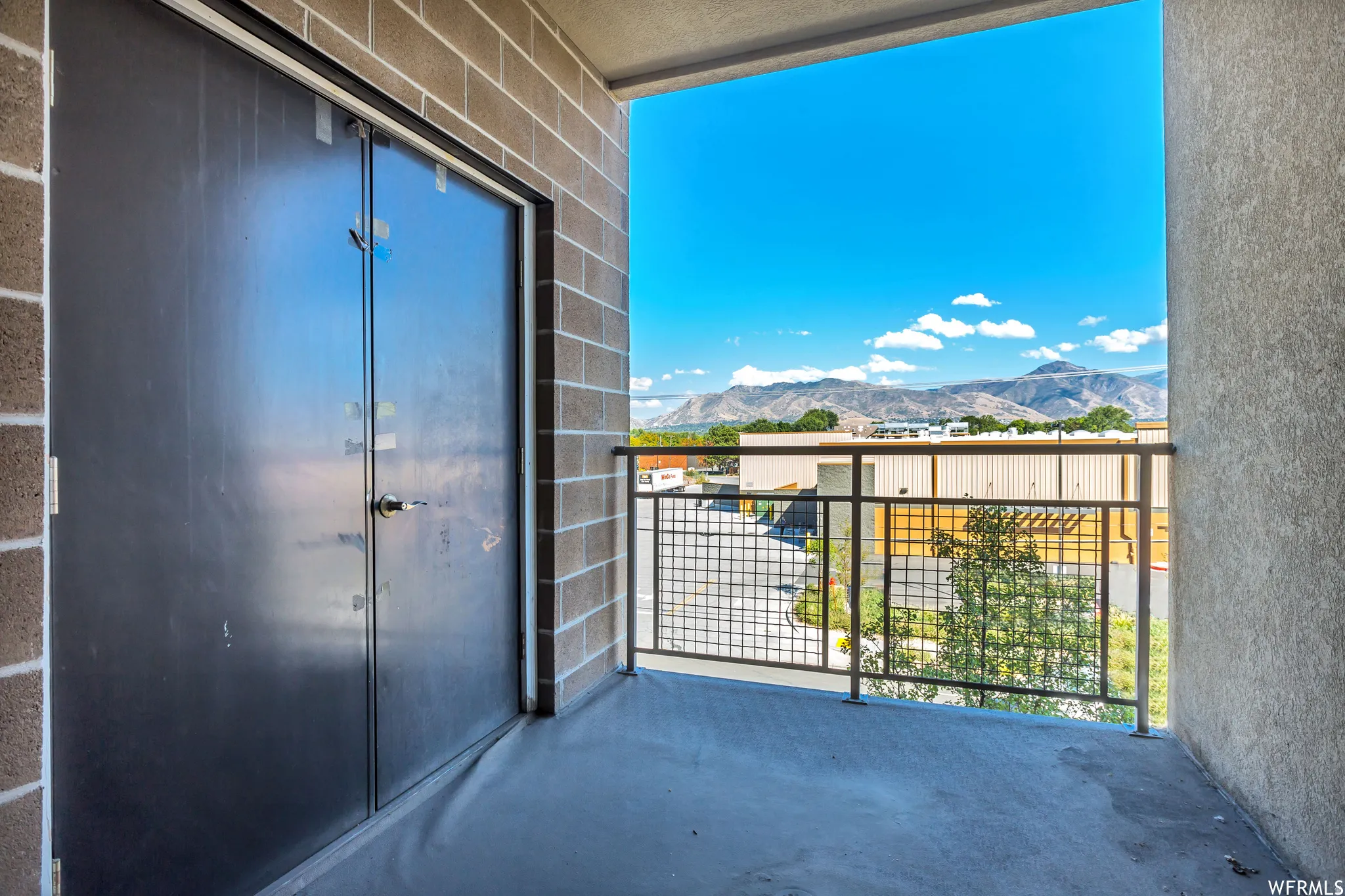 Balcony with mountain backdrop, concrete flooring, and metal railing