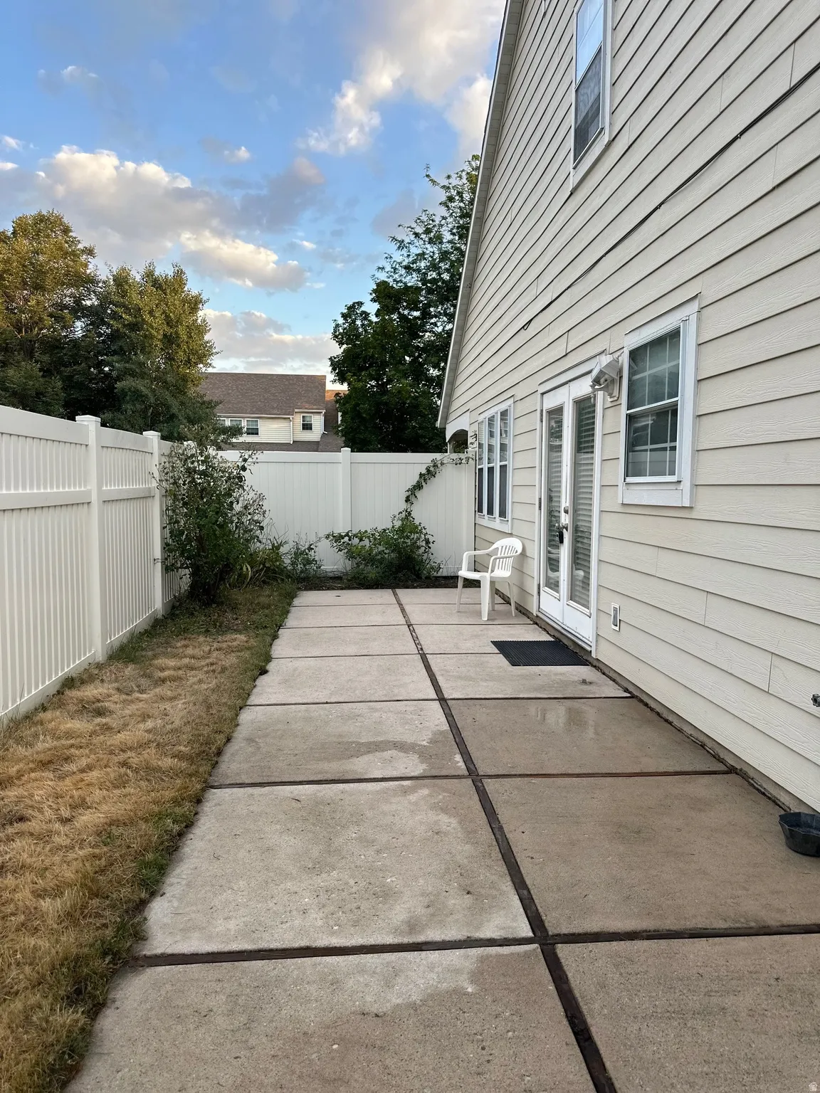Expansive concrete patio offering direct outdoor access through double French doors