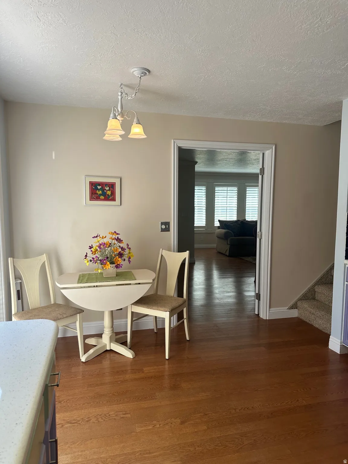 Hardwood flooring, light neutral wall paint, white trim, recessed lighting, carpeted stairs