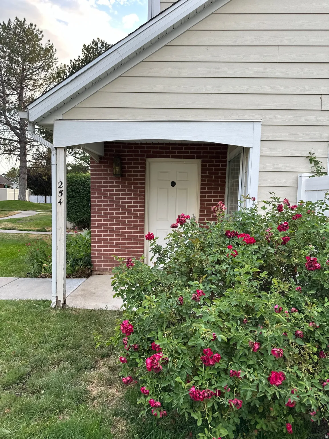 Entryway featuring red brick facade and a covered porch