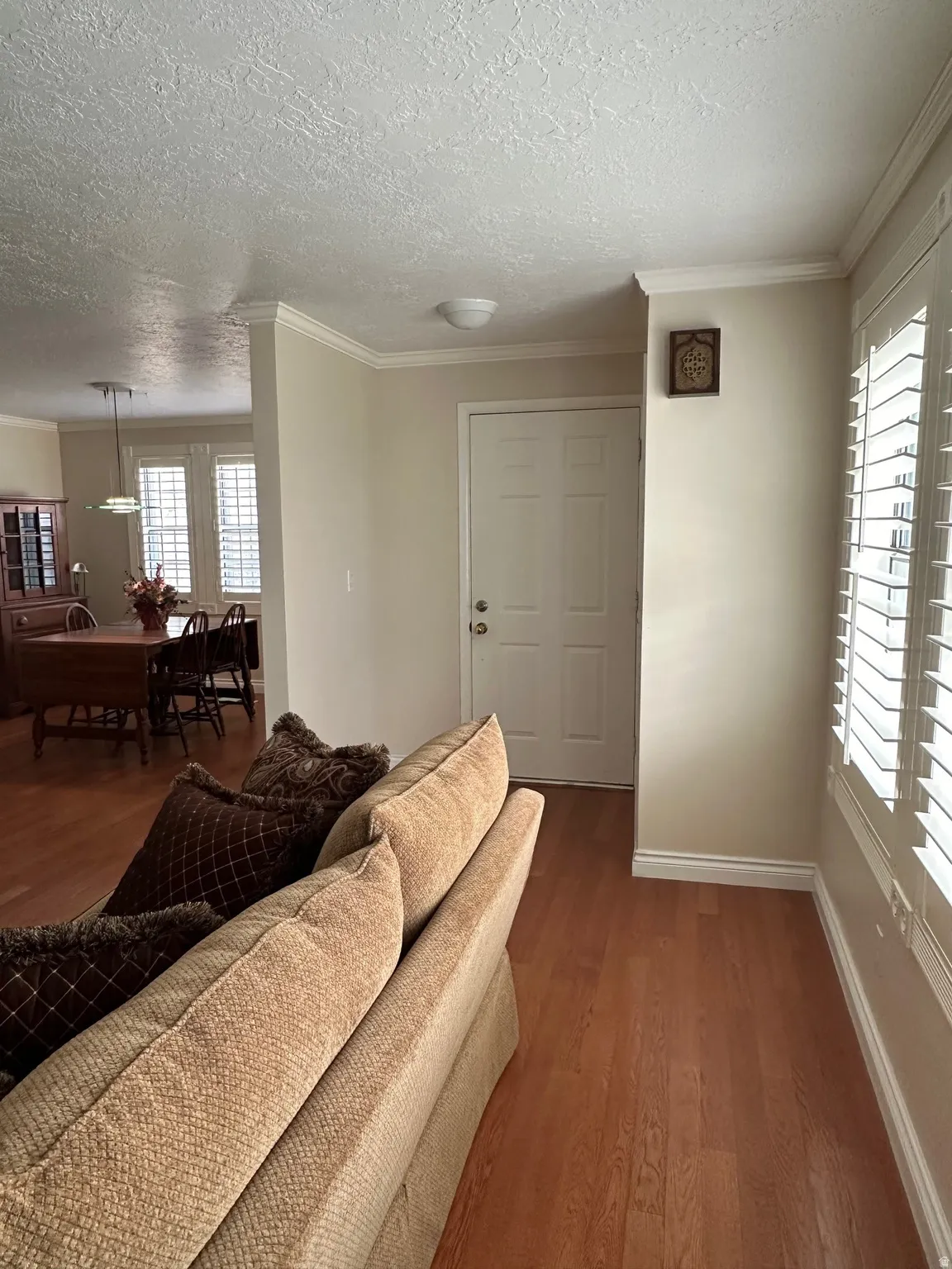 Entryway featuring a paneled door, crown molding, and wood-finish flooring