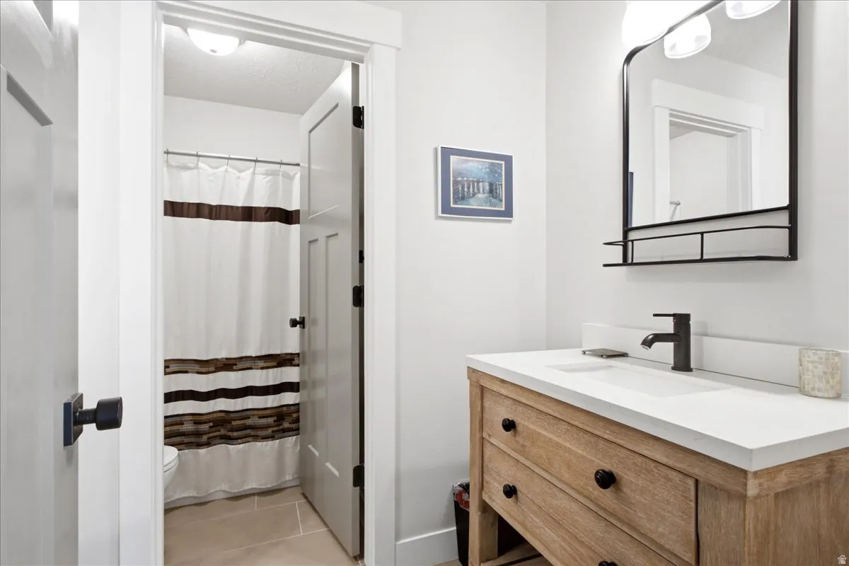 Bathroom featuring a light wood-finish vanity with a white countertop and integrated sink