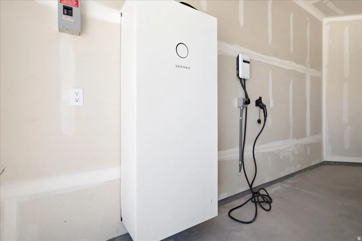 Integrated energy storage system with an electric vehicle charging station, an electrical panel, and wall outlets