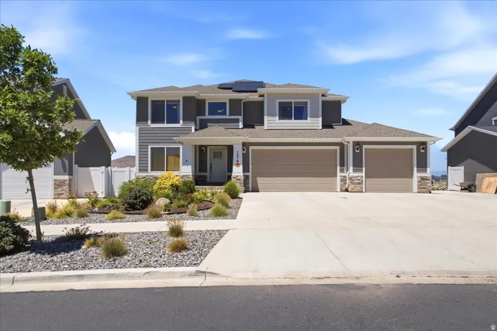 Contemporary two-story residence featuring a gray and white exterior with stone accents