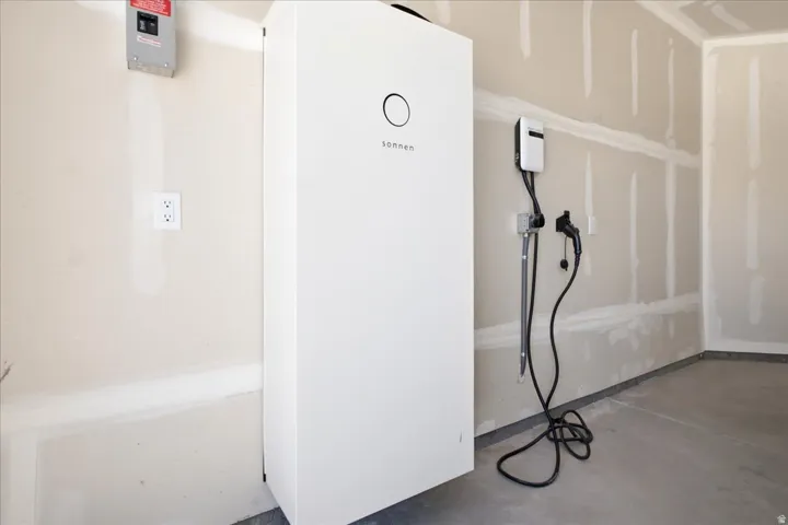 Integrated energy storage system with an electric vehicle charging station, an electrical panel, and wall outlets