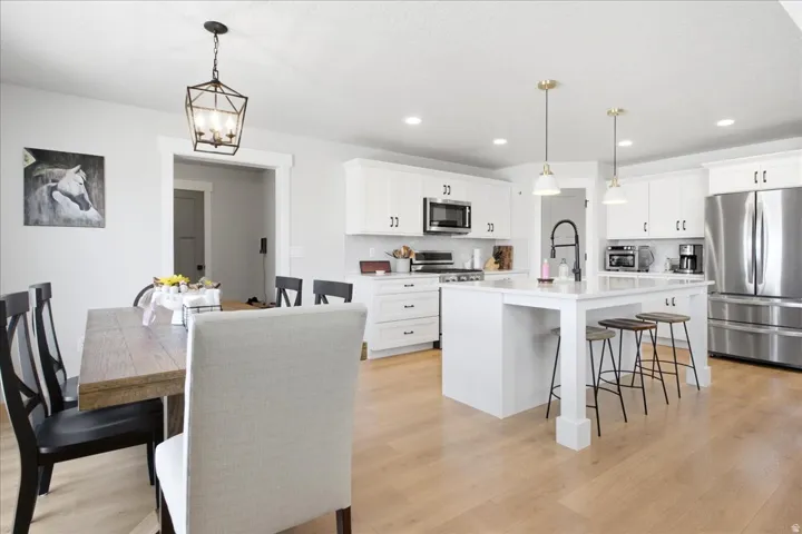 Kitchen and dining area featuring light wood-finish flooring