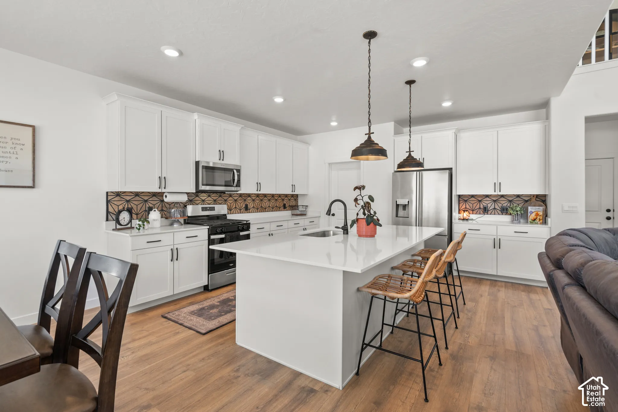 Contemporary kitchen featuring an expansive island with a white countertop and seating for three