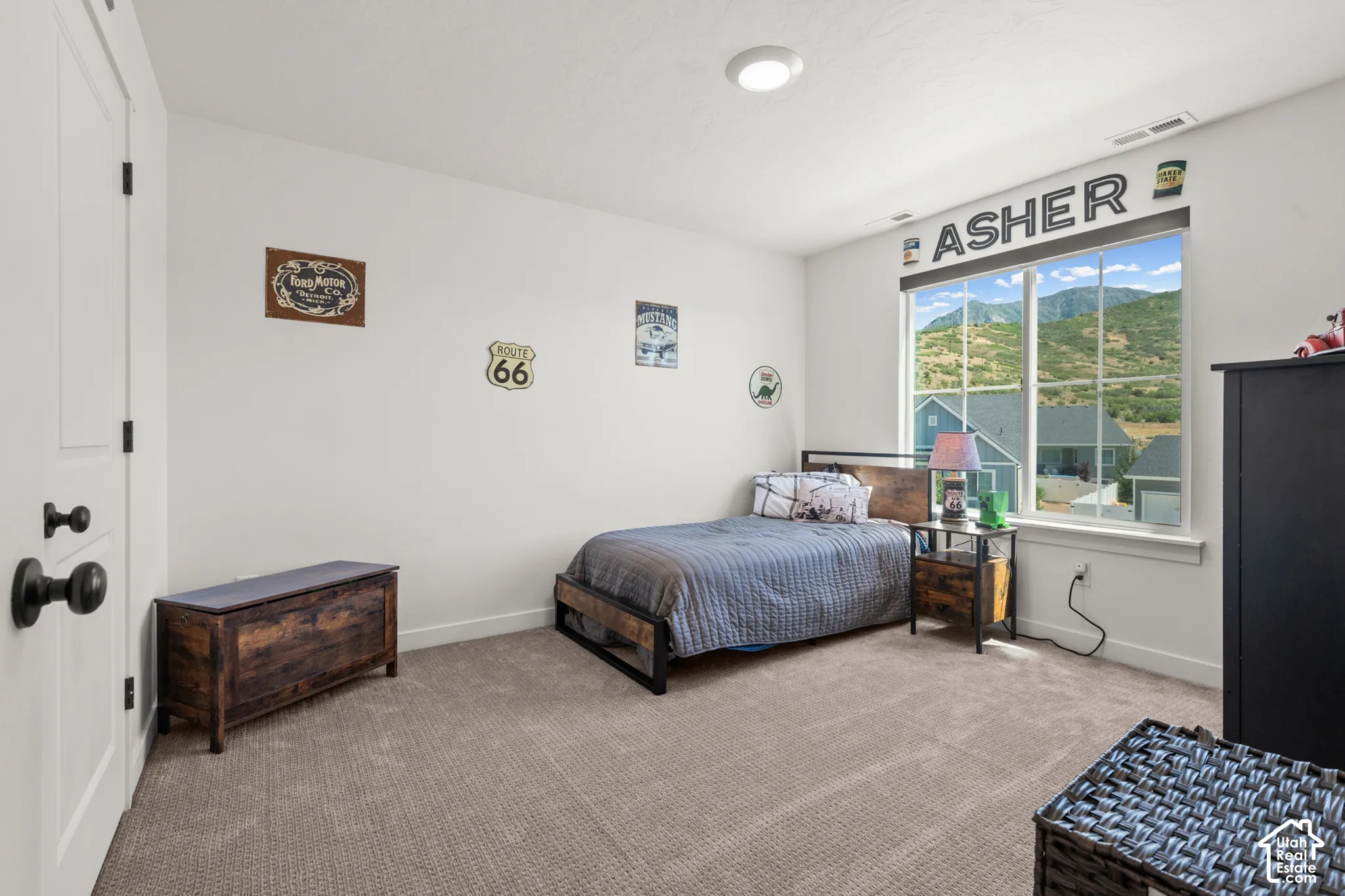 Spacious room featuring a large window, mountain backdrop, white trim, recessed lighting, and soft carpet flooring