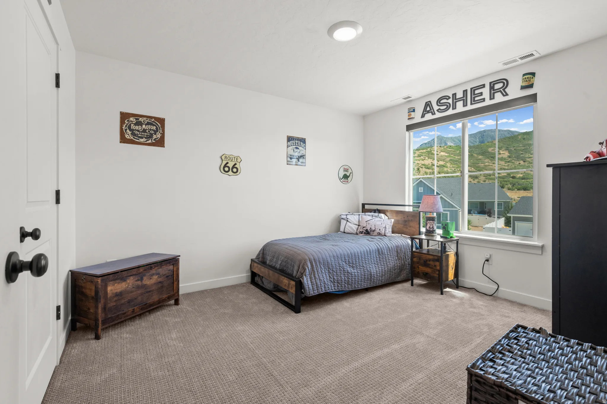 Spacious room featuring a large window, mountain backdrop, white trim, recessed lighting, and soft carpet flooring