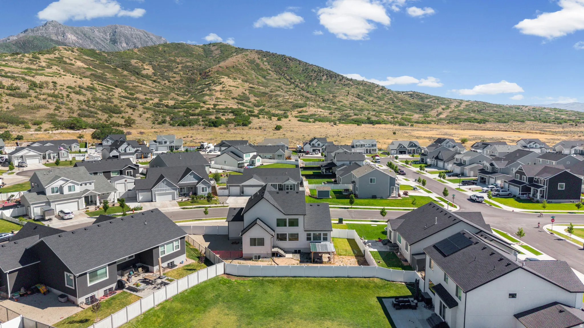 Newly constructed residential development featuring modern homes with dark asphalt shingle roofs and light-colored siding