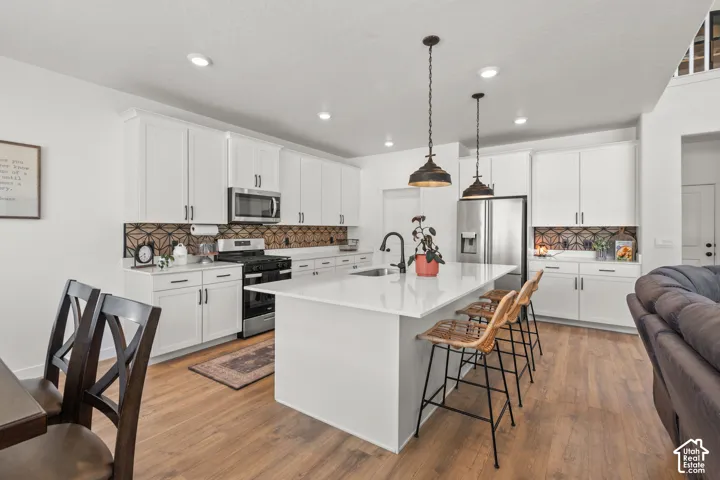 Contemporary kitchen featuring an expansive island with a white countertop and seating for three