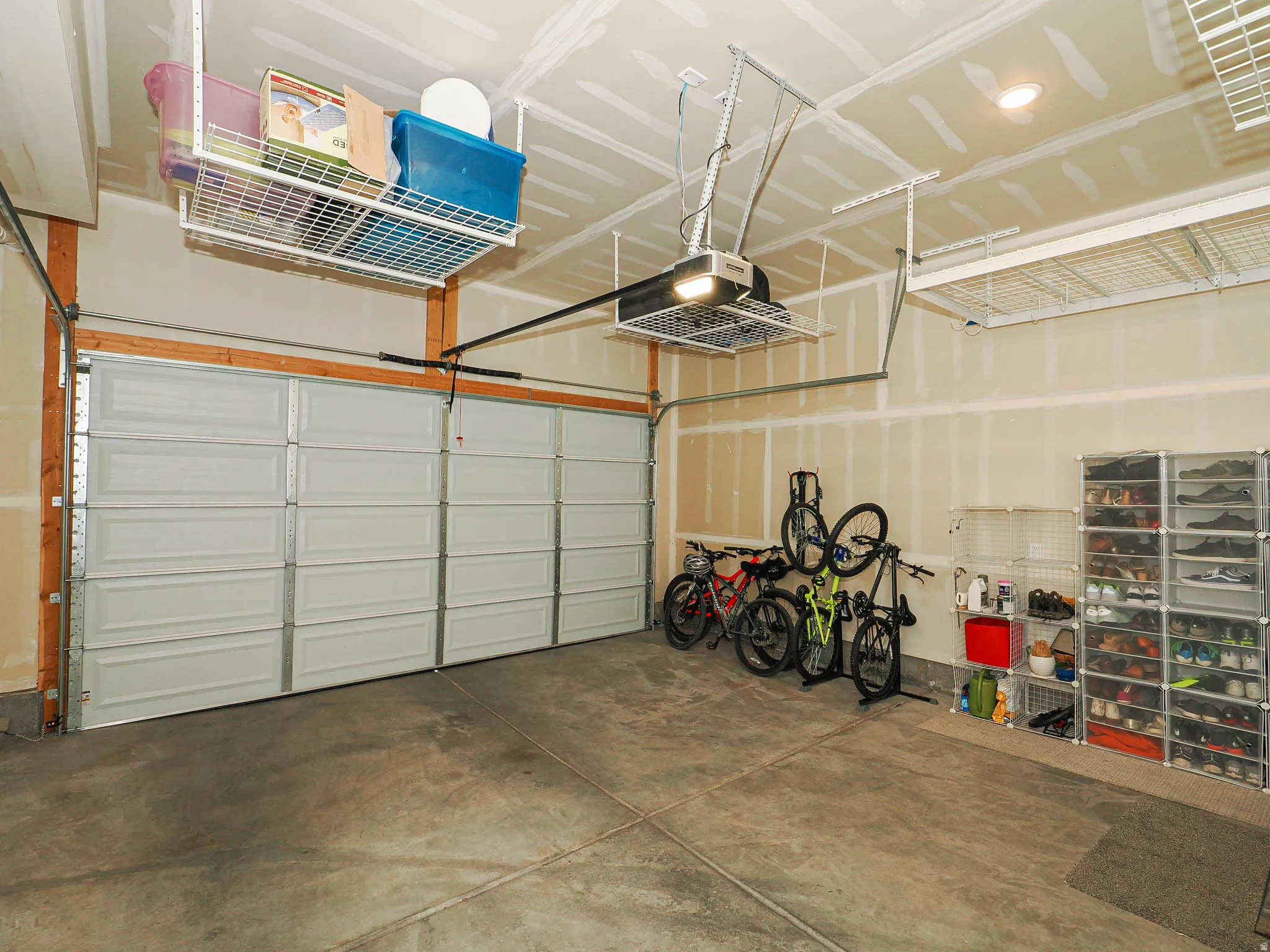 Spacious garage featuring a concrete floor, two paneled garage doors, and overhead storage racks