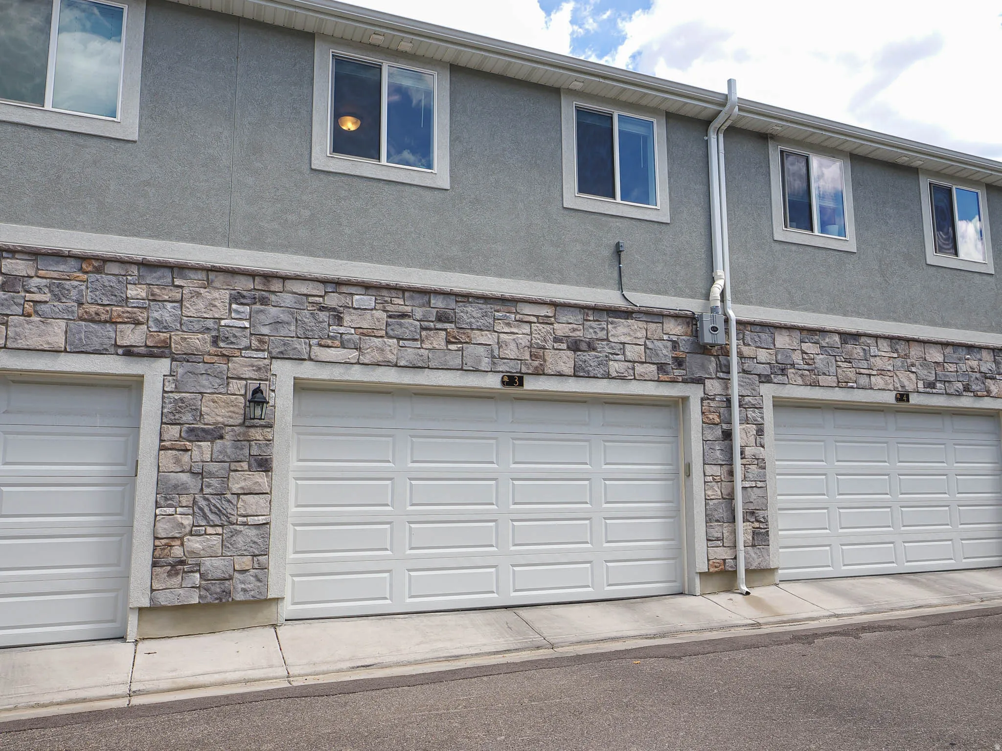 Exterior showcasing a multi-level structure with a combination of stucco and stone veneer siding