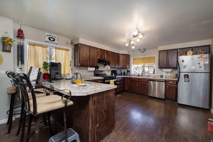 Kitchen with dark wood-finish cabinetry, light-toned countertops, and wood-finish flooring