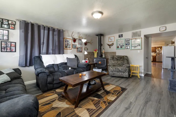 Living area featuring wood-finish flooring, a built-in wood-burning stove with a tiled surround, and a ceiling-mounted light fixture