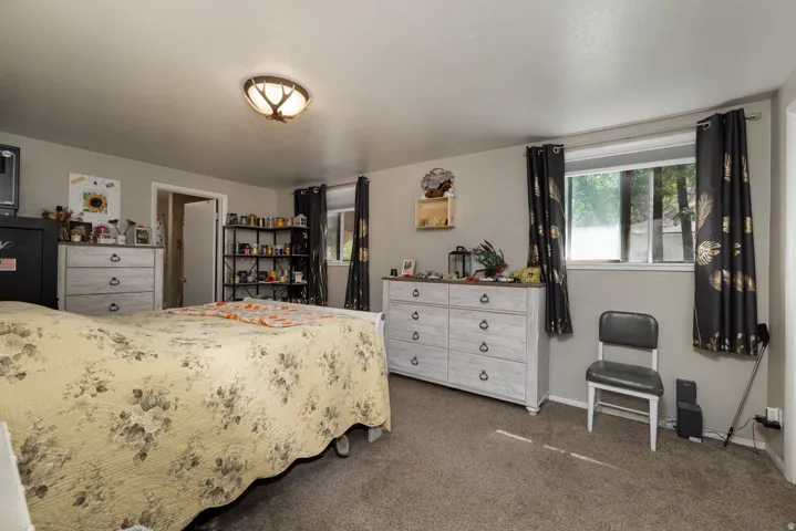 Spacious room featuring carpeted flooring, light-toned wall paint, and a flush-mount ceiling light fixture