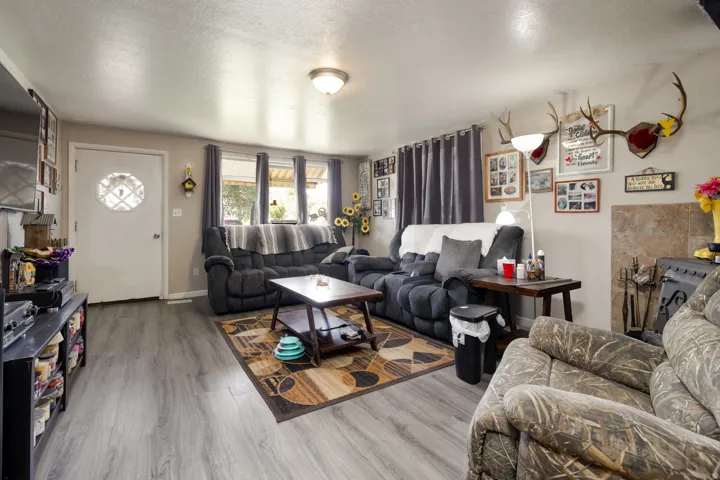 Living area featuring wood-finish flooring, neutral wall tones, and a decorative front entry door with a privacy insert