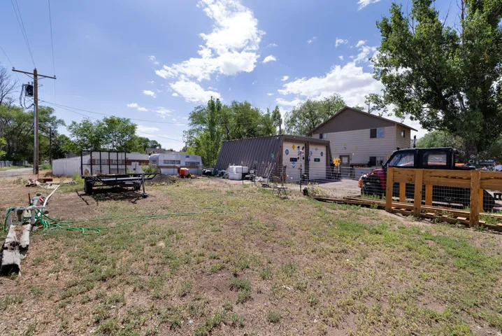Expansive lot featuring a residential structure with tan siding and a brown roof