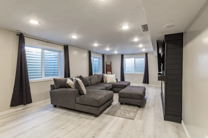 Recessed lighting illuminates this versatile space featuring light wood-finish flooring