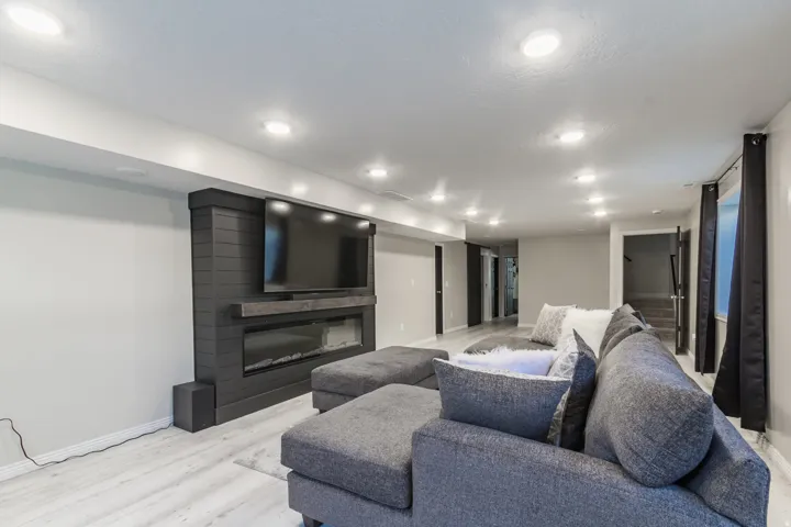 Living area featuring a modern electric fireplace with a dark shiplap surround, a gray mantel, and recessed ceiling lighting