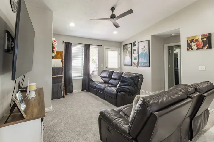 Living area featuring vaulted ceilings, recessed lighting, a ceiling fan, carpet flooring, and window blinds