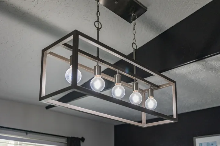 Industrial-style chandelier with an open rectangular frame, suspended by chains from a ceiling fixture