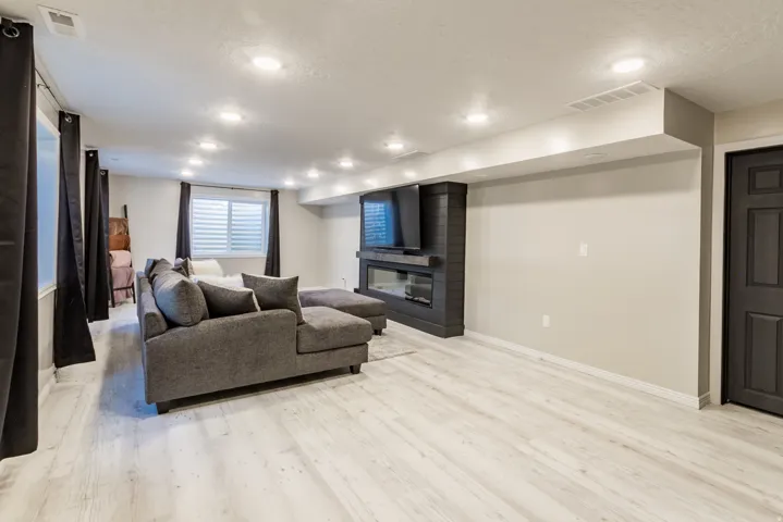 Spacious finished area featuring light wood-finish flooring and recessed ceiling lighting