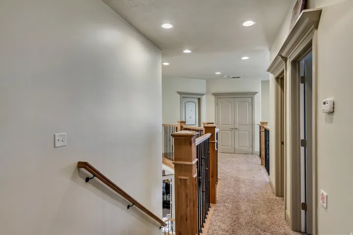 Upper-level hallway featuring recessed lighting and carpet flooring