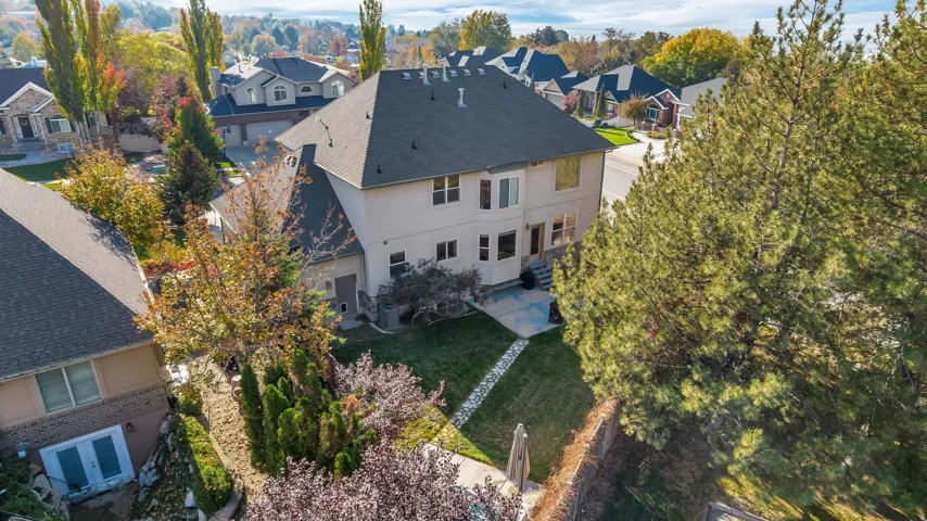 Rear exterior featuring a multi-story design with a light-toned facade and dark shingle roof