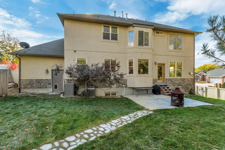 Rear stucco exterior with stone accents and multiple large windows