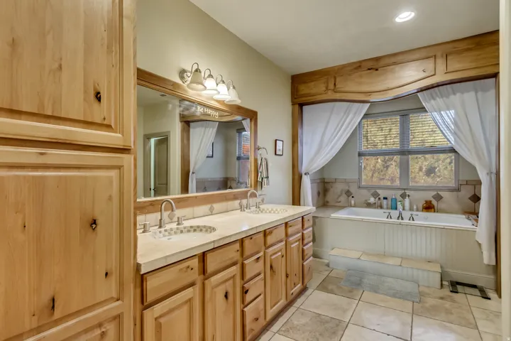 Bathroom featuring a dual vanity with light-toned countertops and undermount sinks