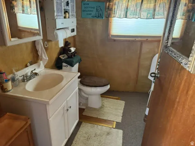 Bathroom vanity with integrated sink, white cabinetry, and wall-mounted mirror